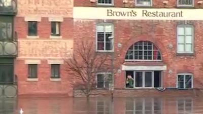 Nathan Roy Smith waving from window of flooded restaurant