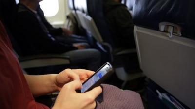 woman uses phone on plane