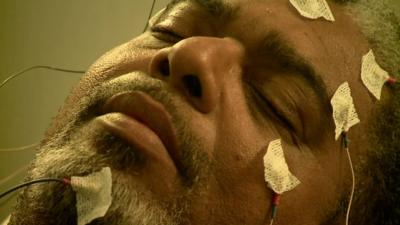 Man's face with sensors that measure sleep