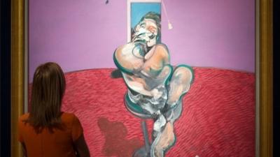 A woman looks the painting by Francis Bacon