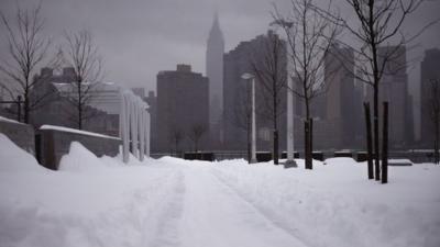 The Empire State Building and the skyline is seen from a path of snow in the Queens borough of New York