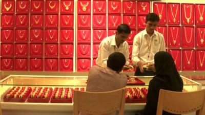 Gold salesmen in Bangalore, India, showing jewellery to two customers