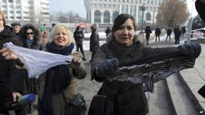 Women hold synthetic lingerie