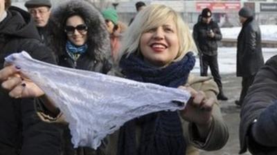 Women hold synthetic lingerie