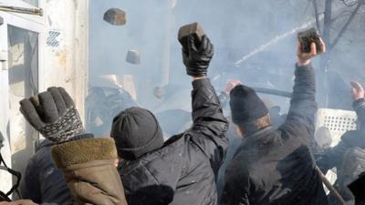 Anti-government protesters throw rocks during clashes with police in Kiev