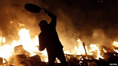 Protester throwing tyre at fire