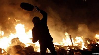 Protester throwing tyre at fire