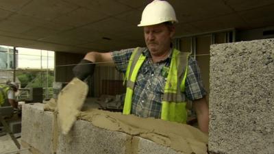 A builder laying blocks