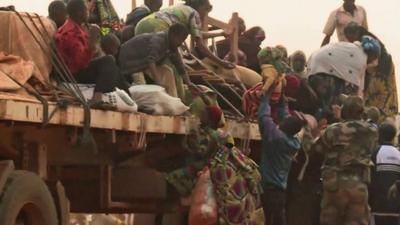 Muslim getting on to a truck, part of a convoy leaving Bangui to CAR