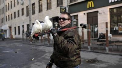 A protester carries doves on a hammer in central Kiev