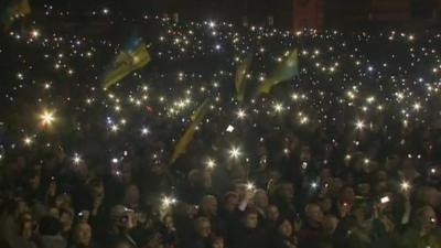 Ukrainian flags and lights shining from mobile phones