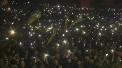 Ukrainian flags and lights shining from mobile phones