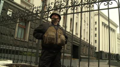 An activist from the Self-Defense group guards the Ukrainian Presidential building in Kiev