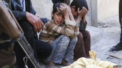 Children react next a body bag after what activists said was a barrel bomb attack in the al-Andhirat neighbourhood of Aleppo on 22 February.