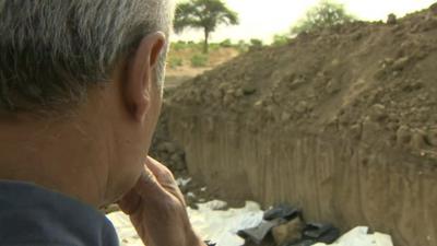 George Alagiah at the site of mass graves