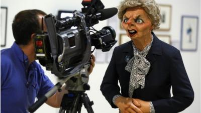 A camera man films the Spitting Image puppet of Margaret Thatcher on display in an exhibition "Rude Britannia : British Comic Art" at Tate Britain