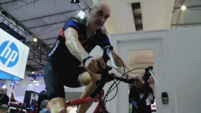 A cyclist demonstrates a new heart rate and blood sugar remote monitoring device at the Mobile World Congress in Barcelona