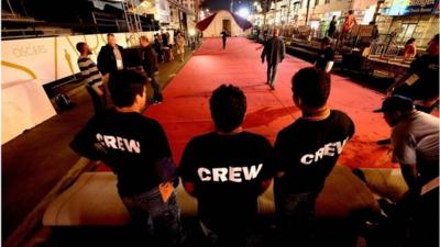 Crew members helping to install the Oscars red carpet