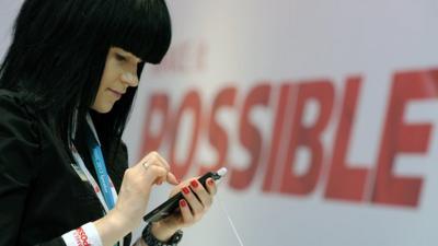 Woman holding mobile phone at Mobile World Congress