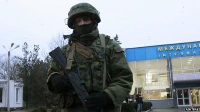 An armed man patrols at the airport in Simferopol, Crimea