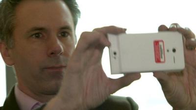 Spencer Kelly holding a Google Project Tango smartphone