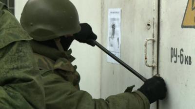 Soldier using crowbar on door