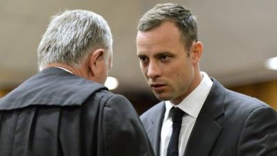 Oscar Pistorius, right, speaks with his lawyer Barry Roux as the start of his trial at the high court in Pretoria, South Africa