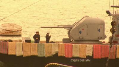 Mattresses draped over side of ship