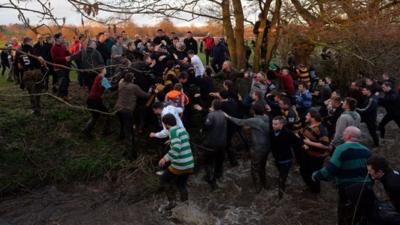 Players push and pull their way through a river