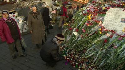 Women leaving flowers and candles