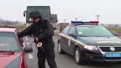 Border guard with car as OSCE vehicles pass