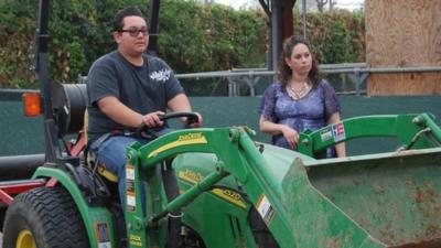 Nathan Talavera drives a tractor with supervision from teacher Jessica Fernandes