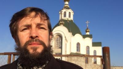 Priest in front of church