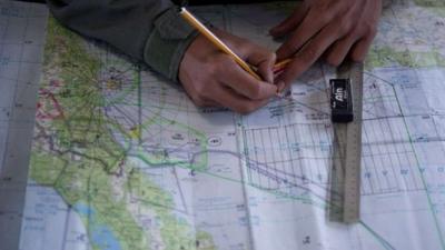 Royal Malaysian Air Force Navigator captain marks locations on a map