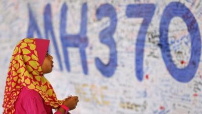 A girl looks at a board with messages of support and hope for passengers of the missing Malaysia Airlines MH370 at the Kuala Lumpur International Airport