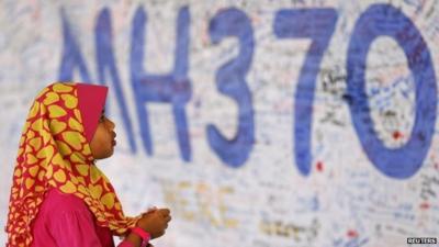 A girl looks at a board with messages of support and hope for passengers of the missing Malaysia Airlines MH370 at the Kuala Lumpur International Airport