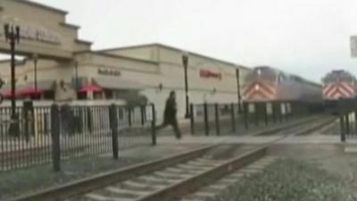 Man runs across train line