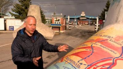 Steve Rosenberg standing by 'tank trap' with map of area on it