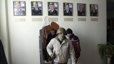 pro-Russian supporter walks through a wall after breaking into the territory of the naval headquarters in Sevastopol