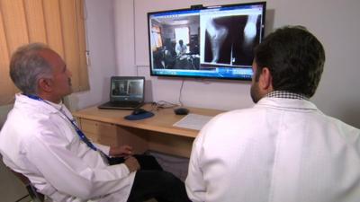 Doctors using a webcam to talk to a patient