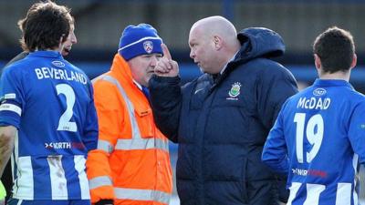 Linfield manager David Jeffrey talks to referee Colin Burns