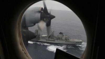 A Royal Australian Air Force AP-3C Orion flies past the HMAS Success as they search for missing Malaysia Airlines flight MH370 debris