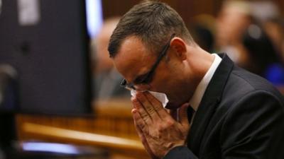 Paralympic track star Oscar Pistorius wipes his nose as he sits in the dock ahead of his trial for the murder of his girlfriend Reeva Steenkamp