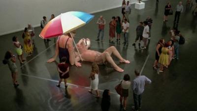 Crowds gathered around a Ron Mueck sculpture