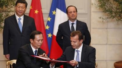 Xi Jinping (back left) and Francois Hollande (back right) watch documents being signed