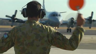 RAAF personnel waving in another search and rescue plane