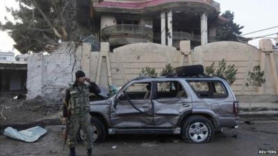 An Afghan security personal stands guard outside a guesthouse, the site of a suicide attack in Kabul on 29 March 2014.