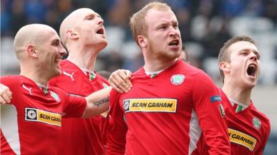 Cliftonville players celebrate victory over Linfield at Windsor Park