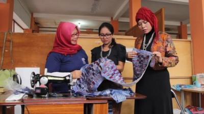 A piece of batik cloth is inspected at the prison workshop