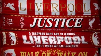 Liverpool scarves, including one asking for justice for the victims of the Hillsborough disaster, for sale on a stall in Liverpool on 26 March 2014